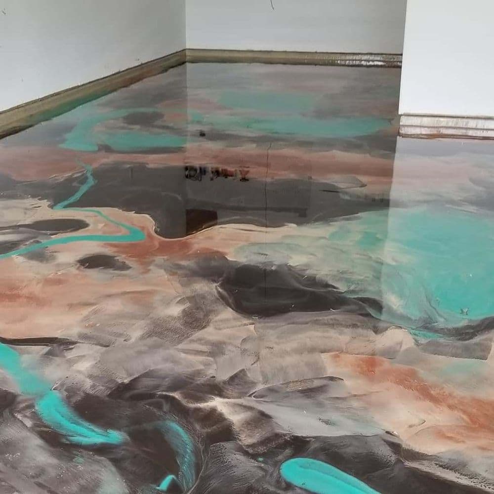 Epoxy resin floor with abstract swirls of teal, brown, and copper in a modern space.